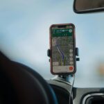 A parent monitoring a car’s location on a smartphone GPS app while a teen drives safely