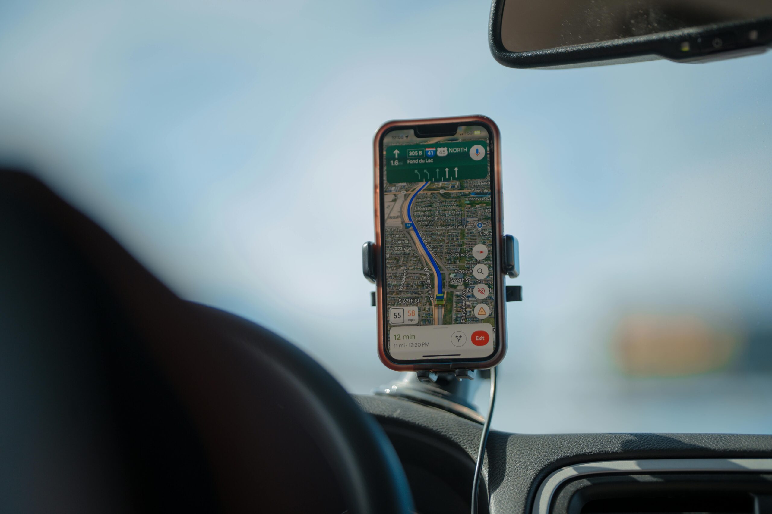 A parent monitoring a car’s location on a smartphone GPS app while a teen drives safely